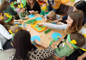 Dzieci wspólnie z rodzicami wykonują prace plastyczną "Kula ziemska"